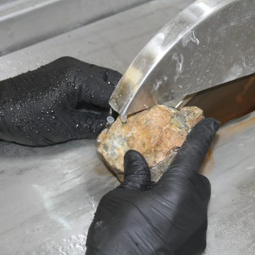 Dans cette photo, le personnel de GeoRessorces procède à la préparation d'échantillons en découpant la roche en vue de réaliser une lame mince pour étudier un fossil de corail.